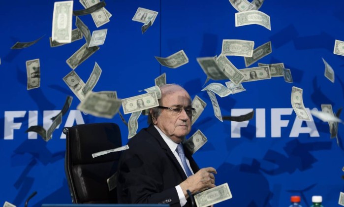 Blatter é alvo de protestos do comediante Simon Brodkin, que atirou um bolo de notas falsas de dólar em cima do presidente da Fifa - (Foto: Fabrice Coffrini/AFP)