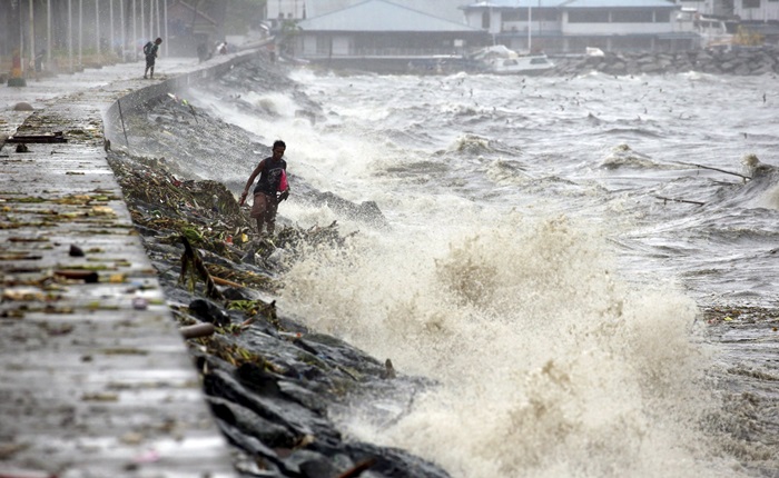 Residentes procuram por materiais recicláveis entre as ondas causadas pelo tufão Koppu em Manila. (Foto: REUTERS/Erik De Castro)