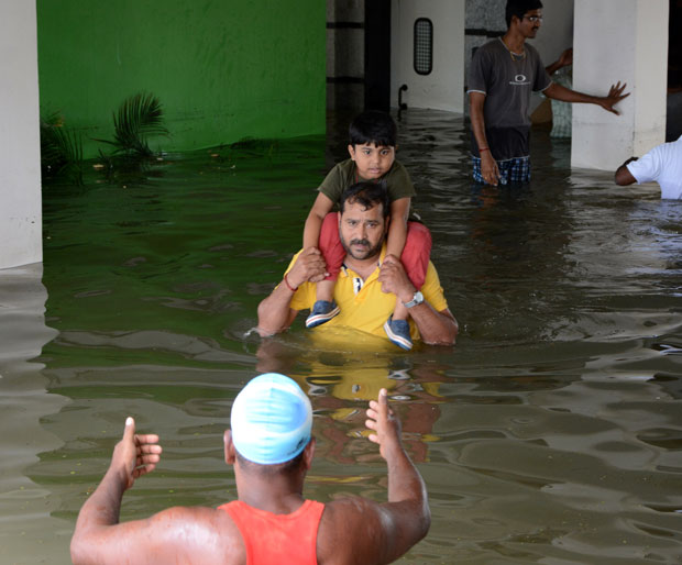 Criança é resgatada durante inundação na região de Chennai, na Índia (Foto: STR/AFP)